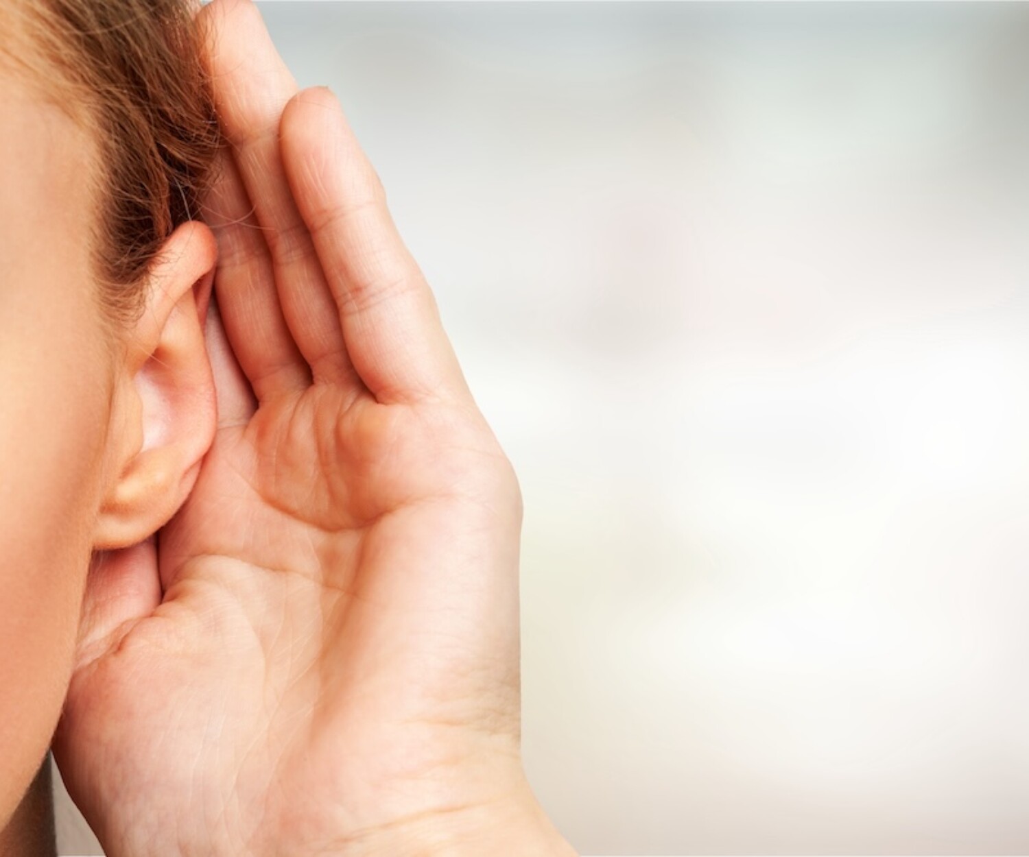 Girl listening with her hand on an